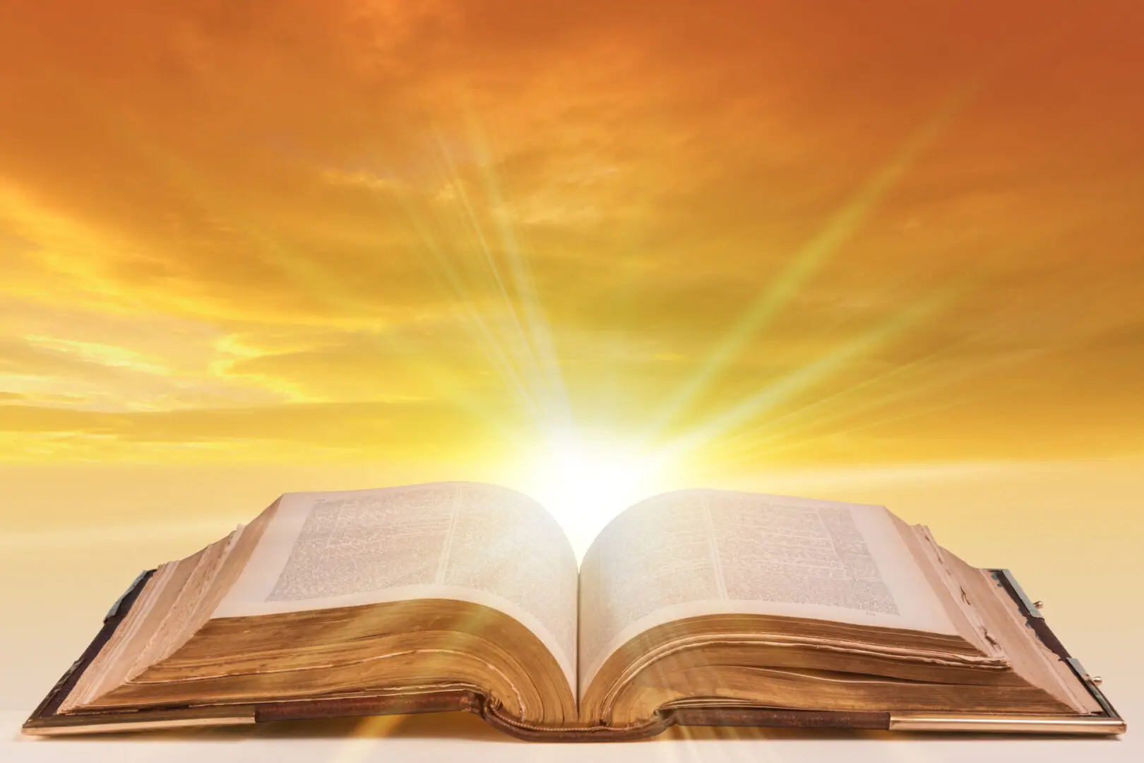 Open book against a sunset sky.