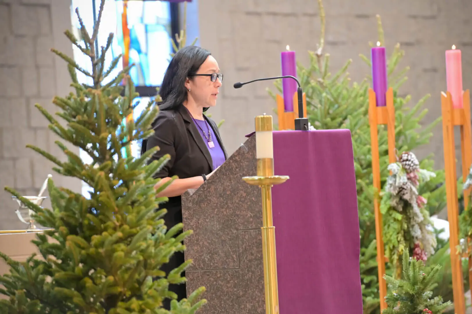 Woman speaking at a church altar.