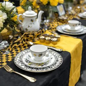 Elegant tea set on yellow and black tablecloth.