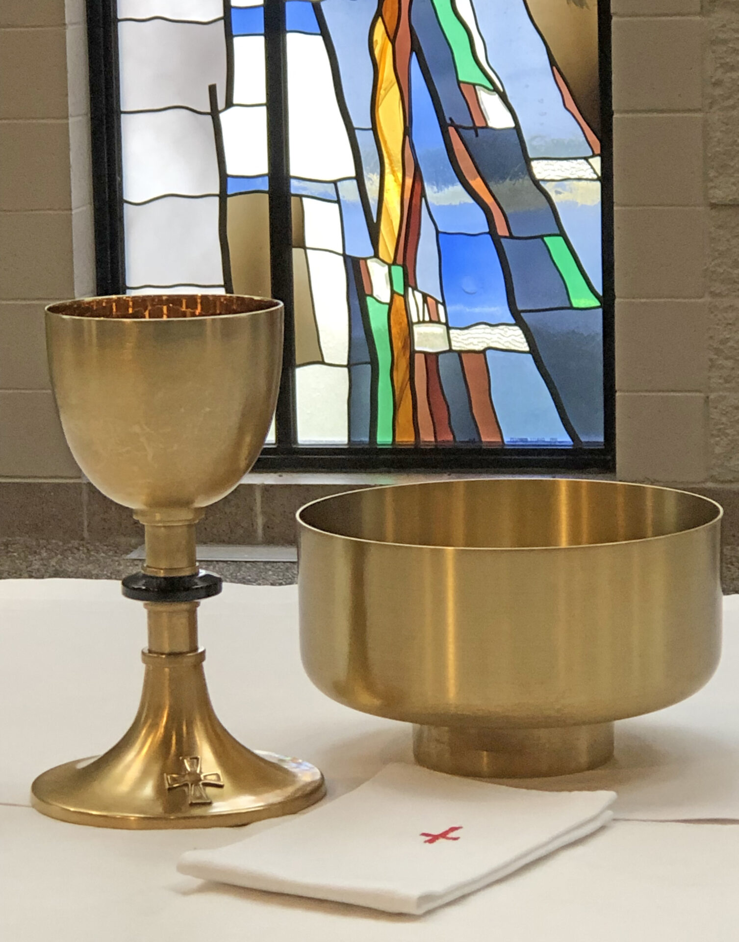 Gold chalice and bowl on altar cloth.