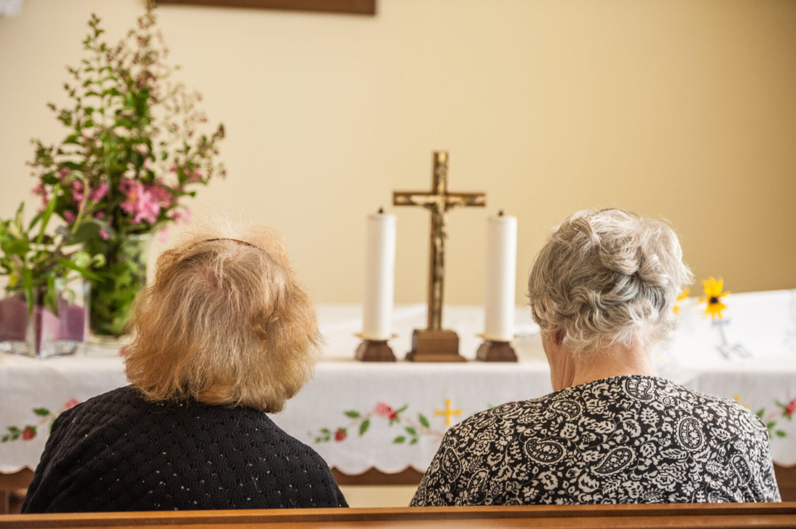 Two Senior Women Praying In The Chapel Of The Retirement Community