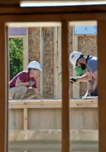 Window view of two workers working at a site