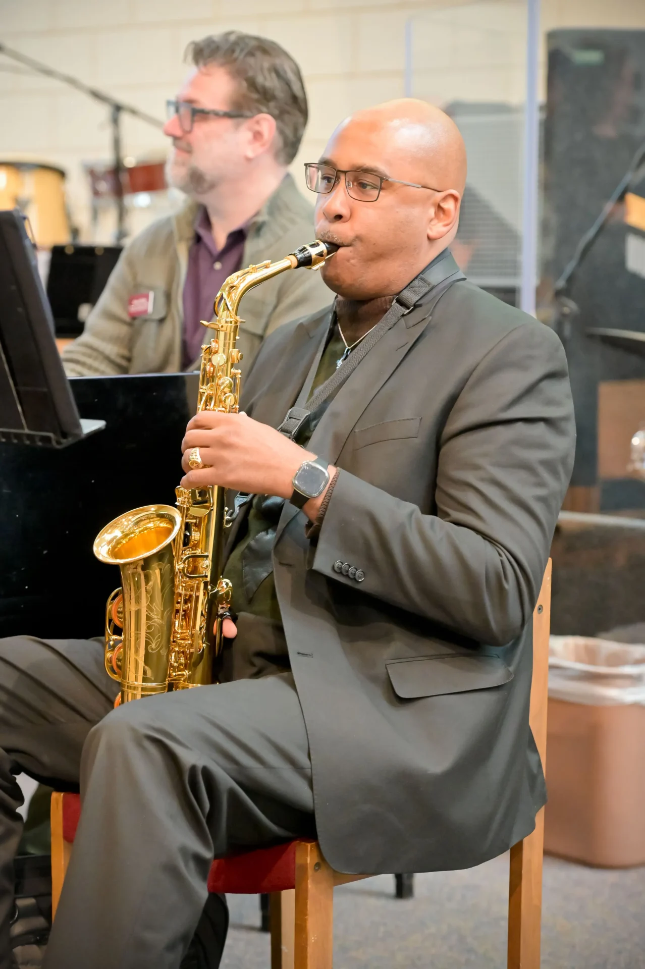 A bald man playing the saxophone.