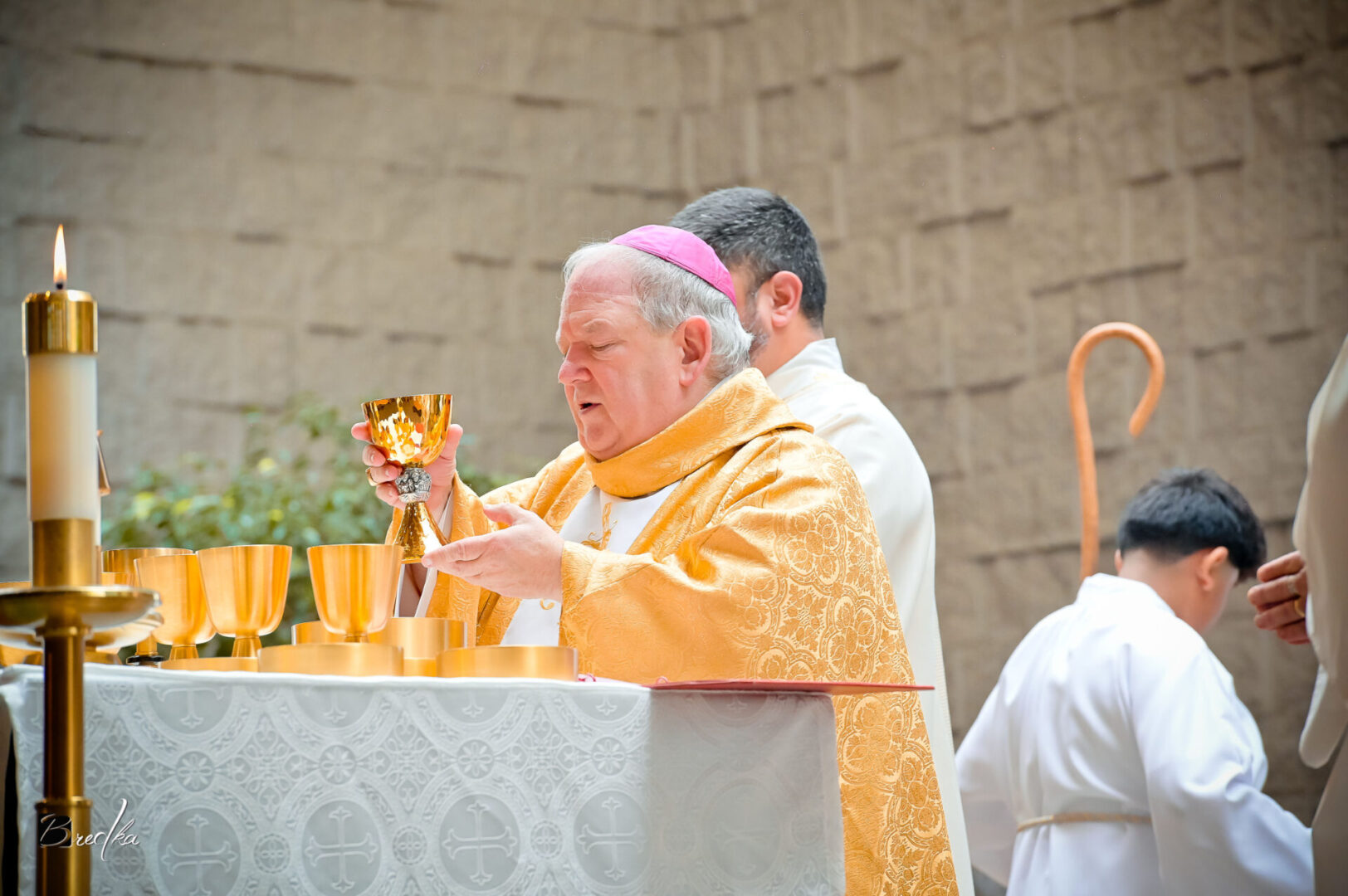 Bishop holding chalice during church service.