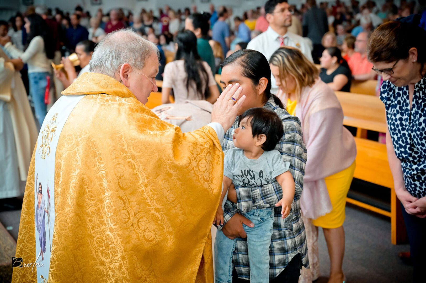 Priest blessing a child in a church.