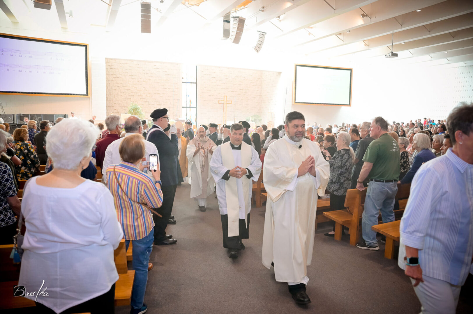 Two priests walking down an aisle.