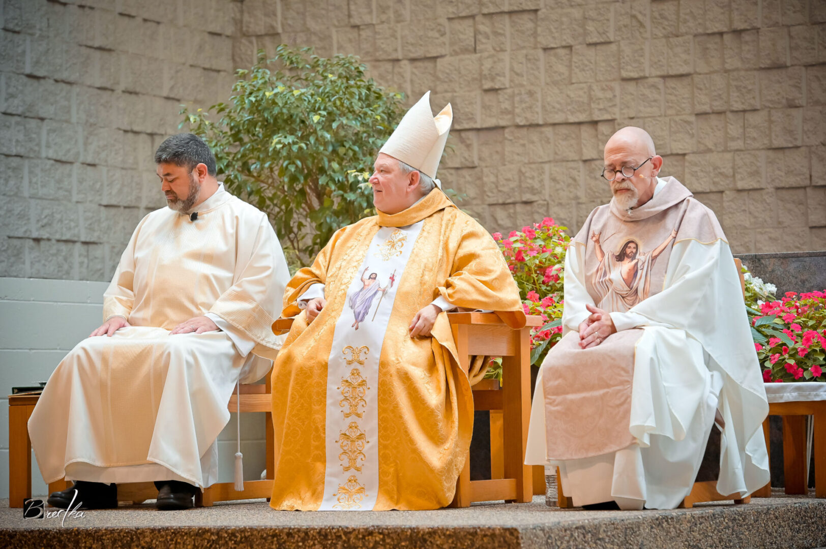 Three men in religious attire seated.
