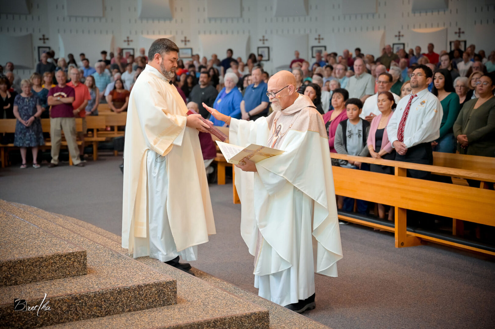 Two priests exchanging a book in church.