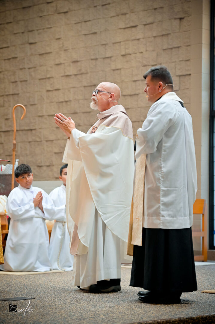 Two priests in white robes during service.