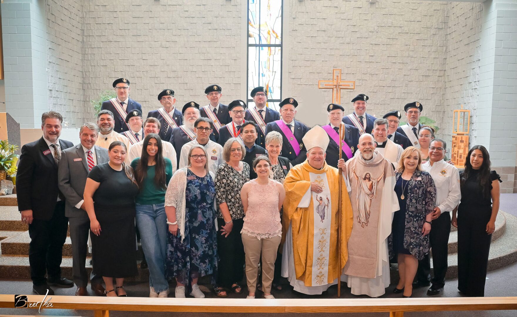 Group of people in church with a bishop.